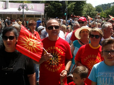Opponents of the deal between Greece and Macedonia on the latter country's new name _ North Macedonia _ hold Macedonian flags as they protest at the village Bitola. AP