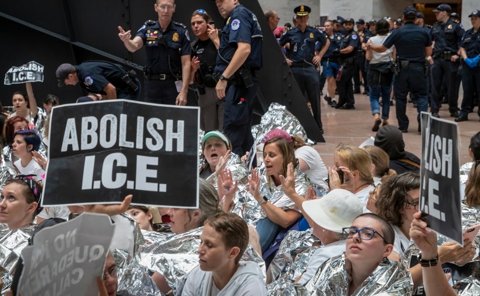The protesters covered themselves in thermal blankets to evoke the image of immigrants' children in shelters. They brandished placards that said The protesters covered themselves in thermal blankets to evoke the image of immigrants' children in shelters. They brandished placards that said