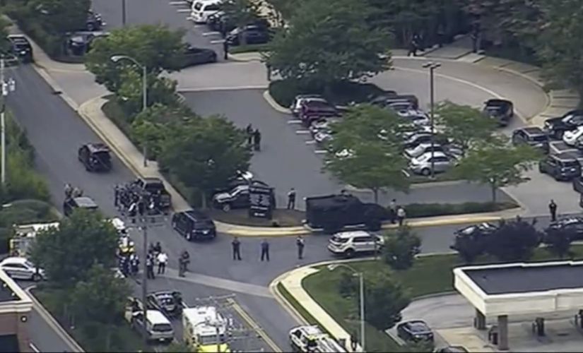 People leave the Capital Gazette newspaper after five people were shot dead on Thursday. AP