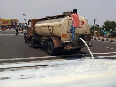 Farmers spill milk down a road during a state-wide protest. PTI