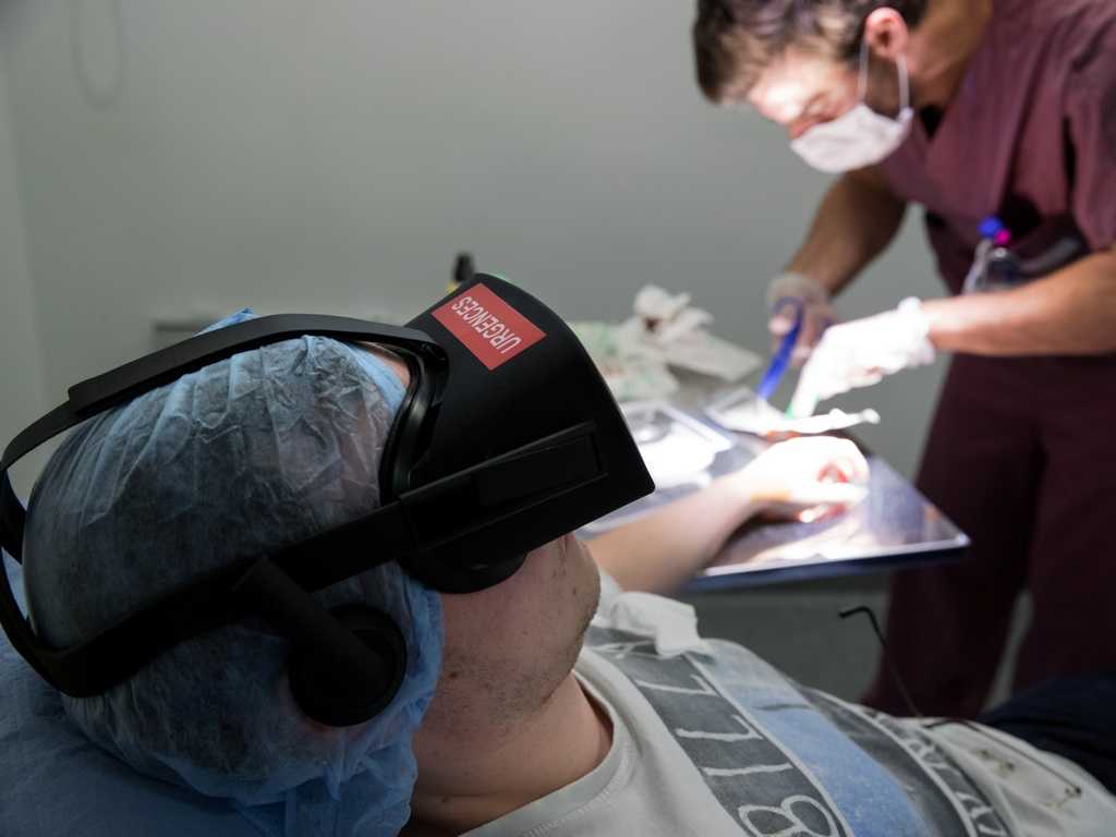 A nurse treats a patient wearing the 3D therapeutic virtual reality headset. Image: Reuters