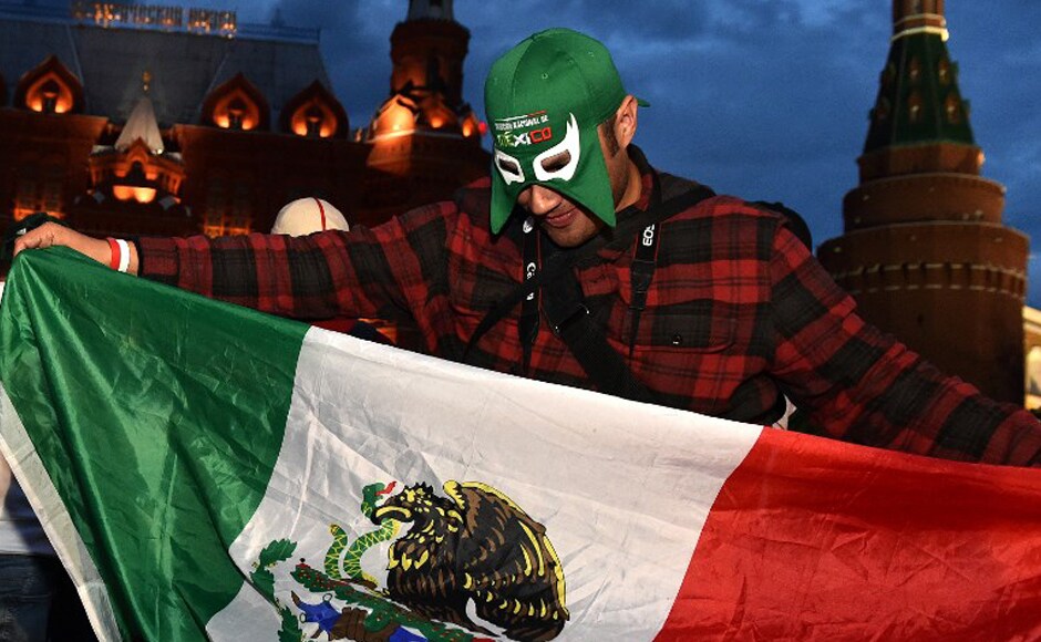 A fan of Mexico's national football team waves a Mexican flag as he cheers outside the Kremlin on 11 June, 2018, in Moscow, ahead of the Russia 2018 football World Cup. AFP. A fan of Mexico's national football team waves a Mexican flag as he cheers outside the Kremlin on 11 June, 2018, in Moscow, ahead of the Russia 2018 football World Cup. AFP.