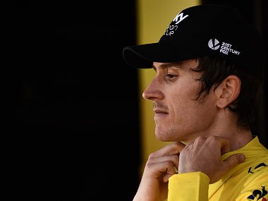 Great Britain's Geraint Thomas puts on the overall leader's yellow jersey on the podium after winning the eleventh stage of the 105th edition of the Tour de France cycling race between Albertville and La Rosiere, French Alps, on July 18, 2018. / AFP PHOTO / Marco BERTORELLO