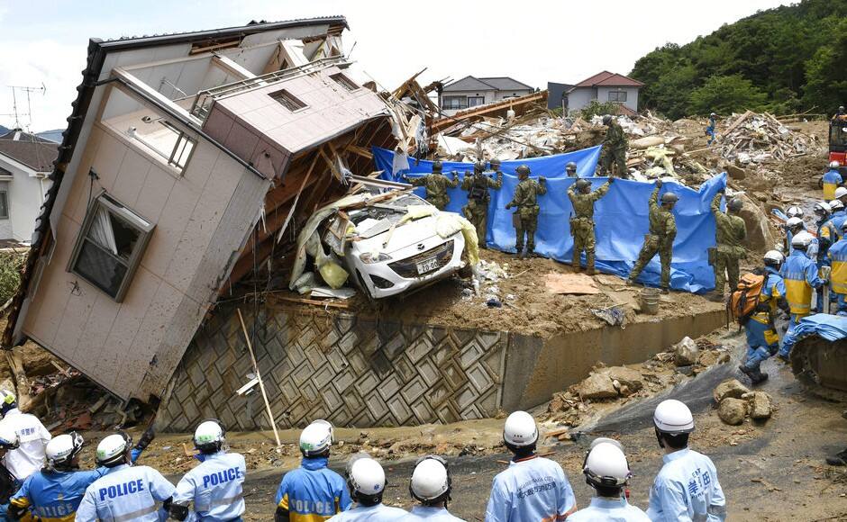 Rescuers conduct a search operation for missing persons in Kumano town, Hiroshima prefecture, western Japan. Chief Cabinet Secretary Yoshihide Suga said Monday that 87 people were confirmed dead and 13 others were without vital signs when they were found. AP