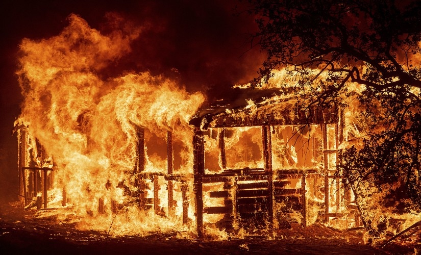 A structure burns as the Carr Fire races along Highway 299 near Redding, California. AP