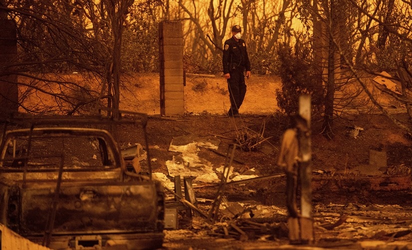 California Highway Patrol officer Gavin Graham surveys homes leveled by the Carr Fire in the Lake Keswick Estates area of Redding. AP