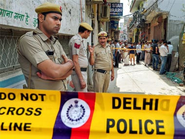   A police guard near the house , where 11 family members - four men, three women and four girls, were found hanging on an iron gate in the Burari area of ​​New Delhi Sunday. PTI 