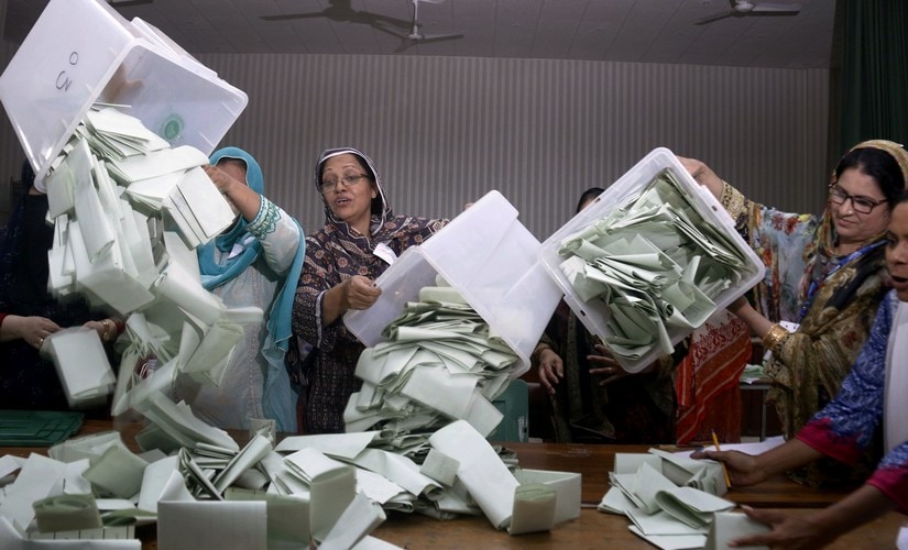 Pakistani election staff empty the ballot boxes in Islamabad. AP