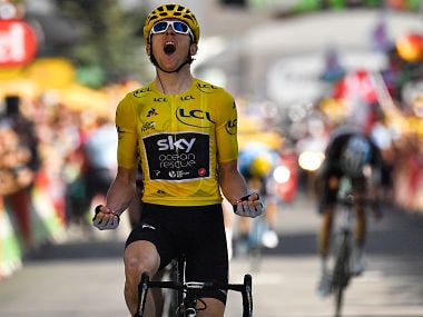 Great Britain's Geraint Thomas, wearing the overall leader's yellow jersey, celebrates as he crosses the finish line to win the twelfth stage of the 105th edition of the Tour de France cycling race, between Bourg-Saint-Maurice - Les Arcs and l'Alpe d'Huez, on July 19, 2018. / AFP PHOTO / Marco BERTORELLO