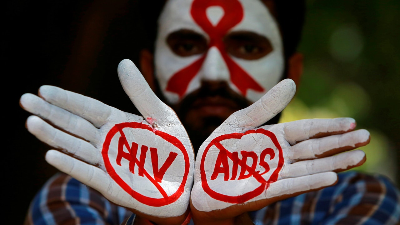 A student displays his hands painted with messages as he poses during an HIV/AIDS awareness campaign to mark the International AIDS Candlelight Memorial, in Chandigarh, India, May 20, 2018. REUTERS/Ajay Verma - RC12F070A300