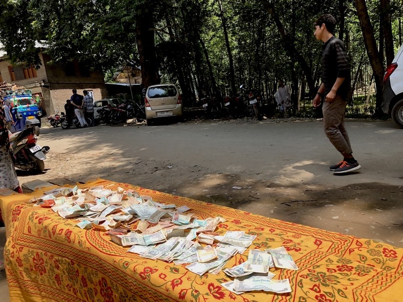 Villagers collect money for the families of those injured or killed in army shooting on Saturday. Sameer Yasir