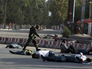 Afghan security personnel and traffic police lie on the ground after a suicide attack near the Kabul Airport. AP