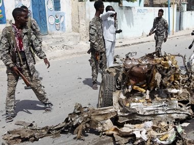 Mogadishu: Soldiers walk near the wreckage of a car bomb near the Somali presidential palace. AP