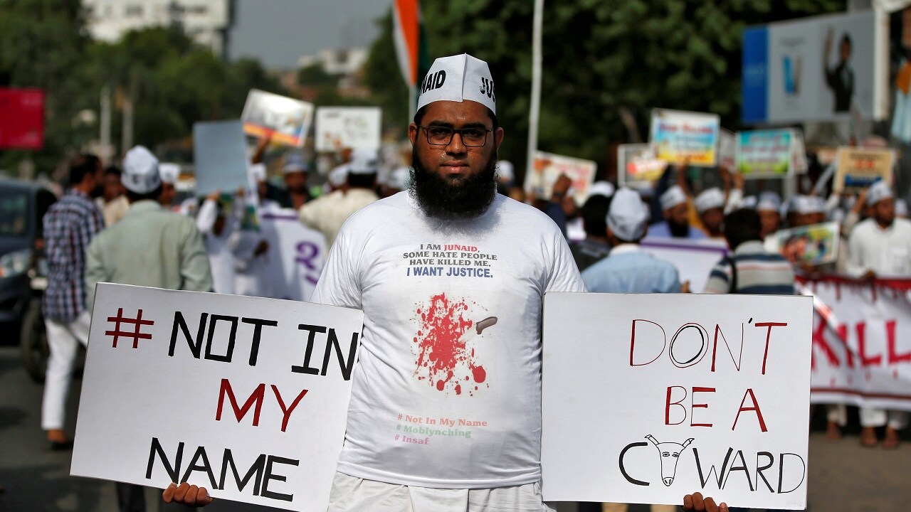 A demonstrator holds placards during a protest against what the demonstrators say recent mob lynching of Muslims and Dalits who were accused of possessing beef, in Ahmedabad, India July 9, 2017. REUTERS/Amit Dave - RC1651CD9140