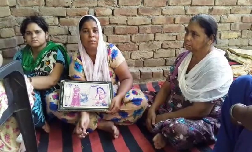 Sukhwinder Kaur holding photo of her husband Surjit Kumar, a drug addict who died recently. Lachhman Jeet Singh Purba