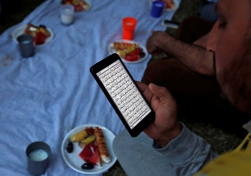 A man reads the Quran on his cellphone. REUTERS