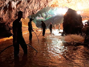 Thai rescue teams arrange water pumping system at the entrance to a flooded cave complex where 12 boys and their soccer coach have been trapped since 23 June. AP