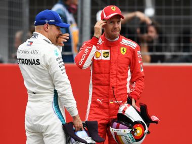 Mercedes' Finnish driver Valtteri Bottas talks with Ferrari's German driver Sebastian Vettel after the qualifying session on the eve of the German Formula One Grand Prix at the Hockenheimring Baden-Württemberg in Hockenheim, on July 21, 2018. Sebastian Vettel surged to pole for his home German Grand Prix ahead of Bottas and Raikkonen. / AFP PHOTO / Christof STACHE