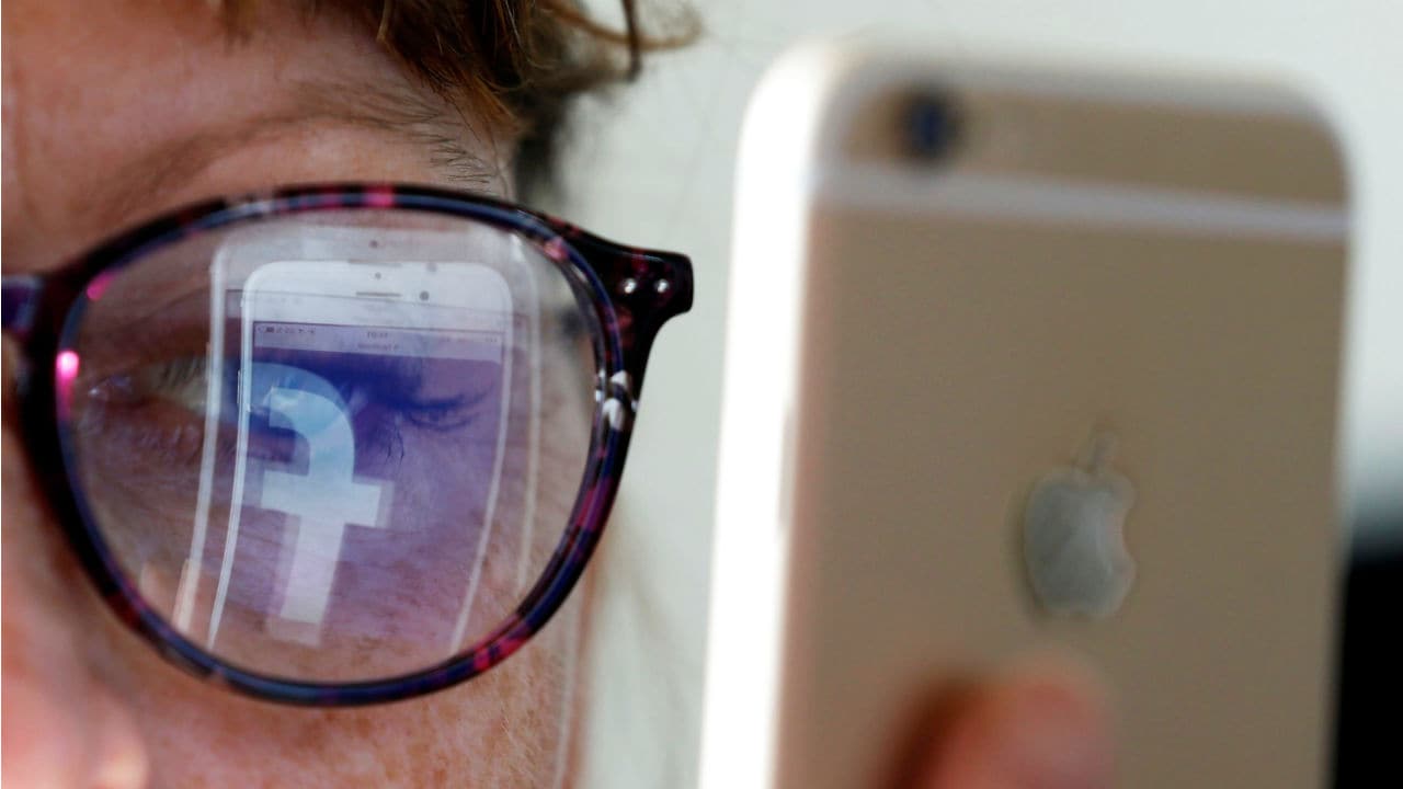 Reflection of the Facebook logo on a woman's spectacles. Image: Reuters 