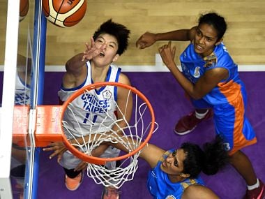 Taiwan's Wang Weilin (L) shoots against India in the women's basketball preliminary Group A game between Taiwan and India at the 2018 Asian Games in Jakarta on August 19, 2018. / AFP PHOTO / Lillian SUWANRUMPHA