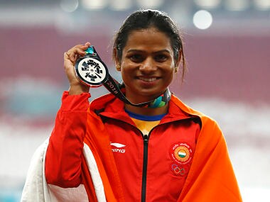 India's Dutee Chand celebrates on the podium after winning the silver medal in the women's 100m final during the athletics competition at the 18th Asian Games in Jakarta, Indonesia, Sunday, Aug. 26, 2018. (AP Photo/Bernat Armangue)