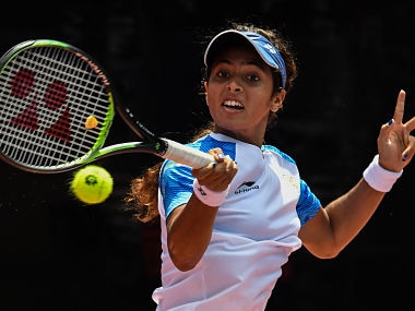 India's Ankita Ravinderkrishan Raina hits a return against Indonesia's Beatrice Gumulya in their women's singles tennis match during the 2018 Asian Games in Palembang on August 20, 2018. / AFP PHOTO / Mohd RASFAN