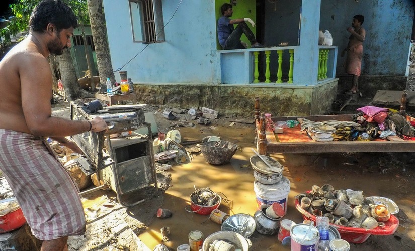 A man cleans up his house after flood water subsided at Chengannur district of the Kerala. PTI