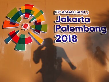 A man passes a signage at the media center ahead of the Asian Games in Palembang, South Sumatra, Indonesia August 16, 2018. REUTERS/Edgar Su - RC1D55A16750