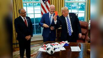US President Donald Trump shows press red card after welcoming FIFA boss Gianni Infantino to the White House