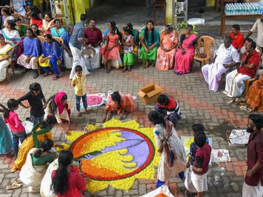Women make a 'rangoli' as they celebrate 'Onam' at a flood relief camp in Kochi on Saturday. PTI