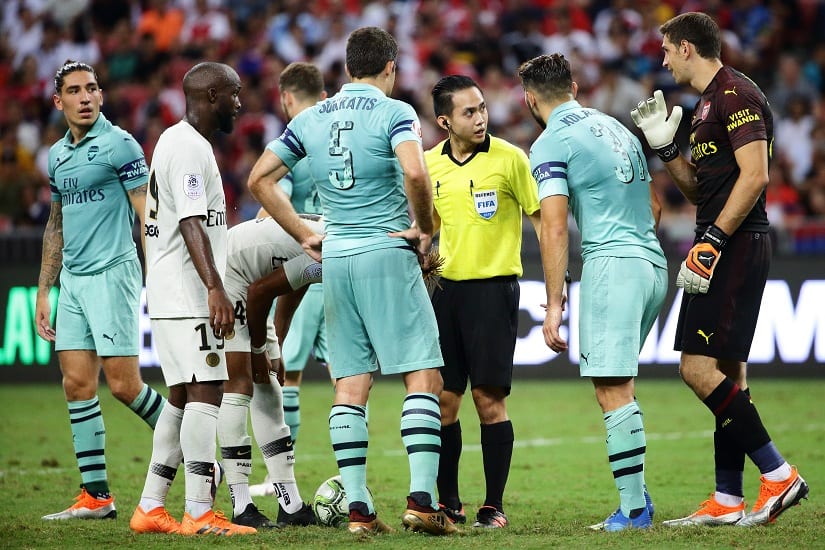 Sokratis Papastathopoulos and Sead Kolasinac argue with the referee for awarding a penalty to PSG. International Champions Cup 2018/Getty Images