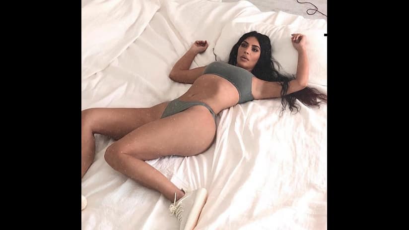 Kim Kardashian posing for Yeezy Boost 350 V2 Butter trainers. Instagram/ @kimkardashian