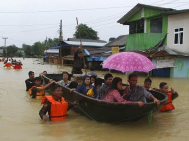 Members of Myanmar Rescue Team carry residents in a boat to travel along a flooded road in Bago, Myanmar. AP