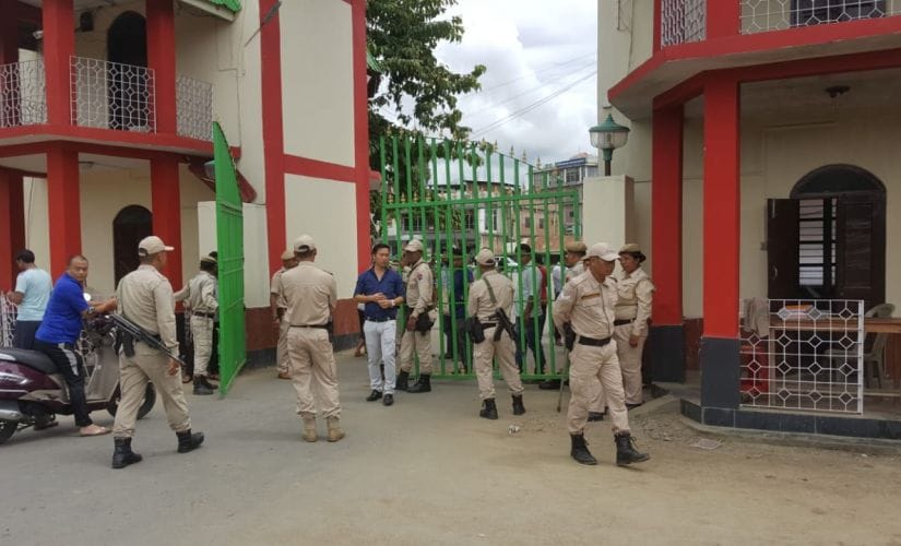 Police force stand at guard at the gates of the Manipur University. Image by Sunzu Bachaspatimayum