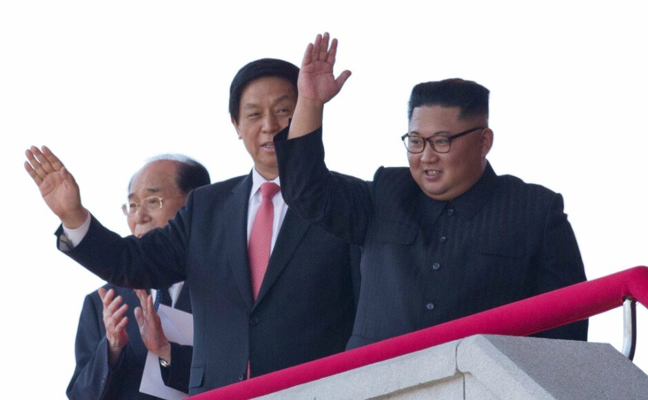 Kim, right, waves with China's third-highest ranking official, Li Zhanshu, center during the parade. AP Kim, right, waves with China's third-highest ranking official, Li Zhanshu, center during the parade. AP