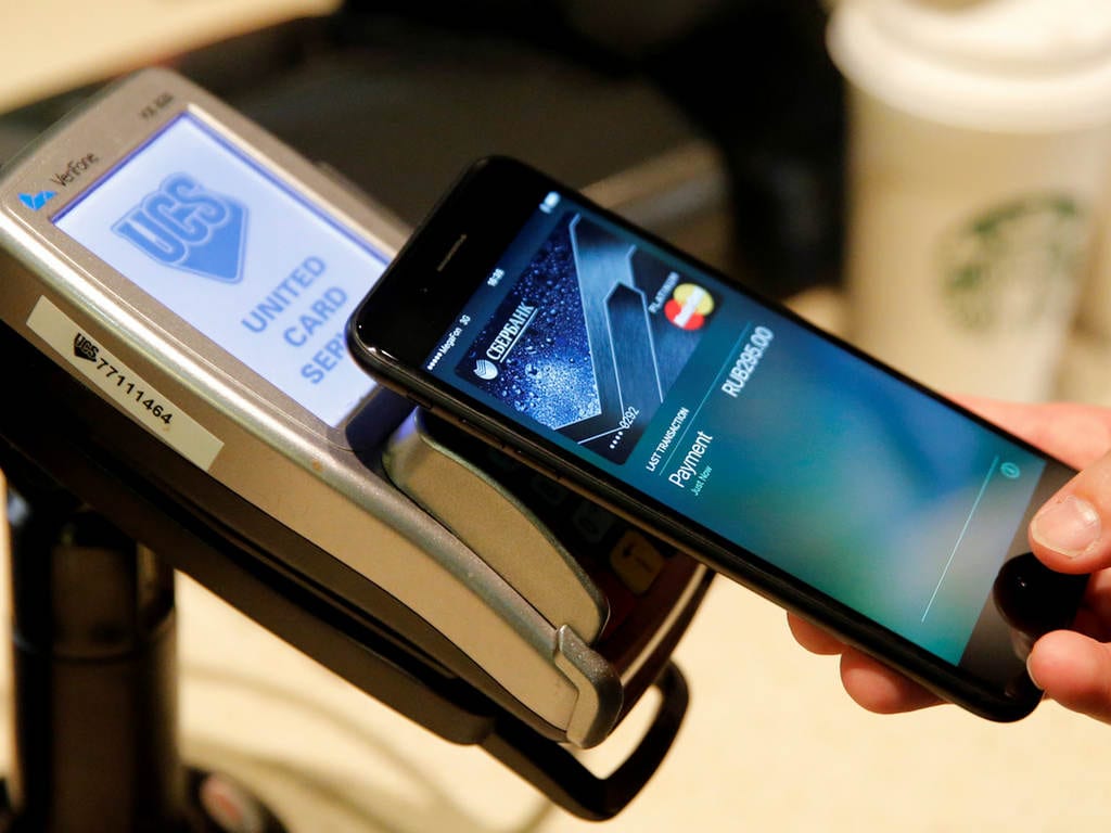 A man uses an iPhone 7 smartphone to demonstrate the mobile payment service Apple Pay at a cafe in Moscow, Russia, October 3, 2016. Picture taken October 3, 2016. REUTERS/Maxim Zmeyev - S1BEUEYZNGAB