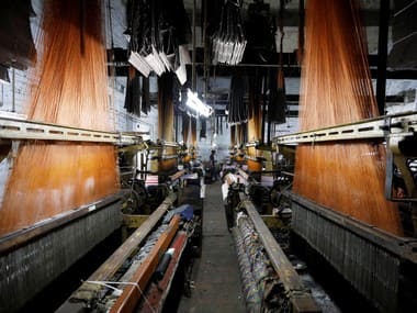 A labourer works on a powerloom machine inside a weaving factory in Panipat, Haryana. Reuters