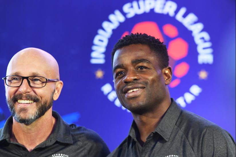 Northeast United FC Head coach Eelco Schattorie (L) and player Bartholomew Ogbeche of the Indian Super League (ISL) pose for a picture during an event in Kolkata on September 22, 2018. This will be the fifth season of the Indian Super League, since its establishment in 2014. / AFP PHOTO / Dibyangshu SARKAR