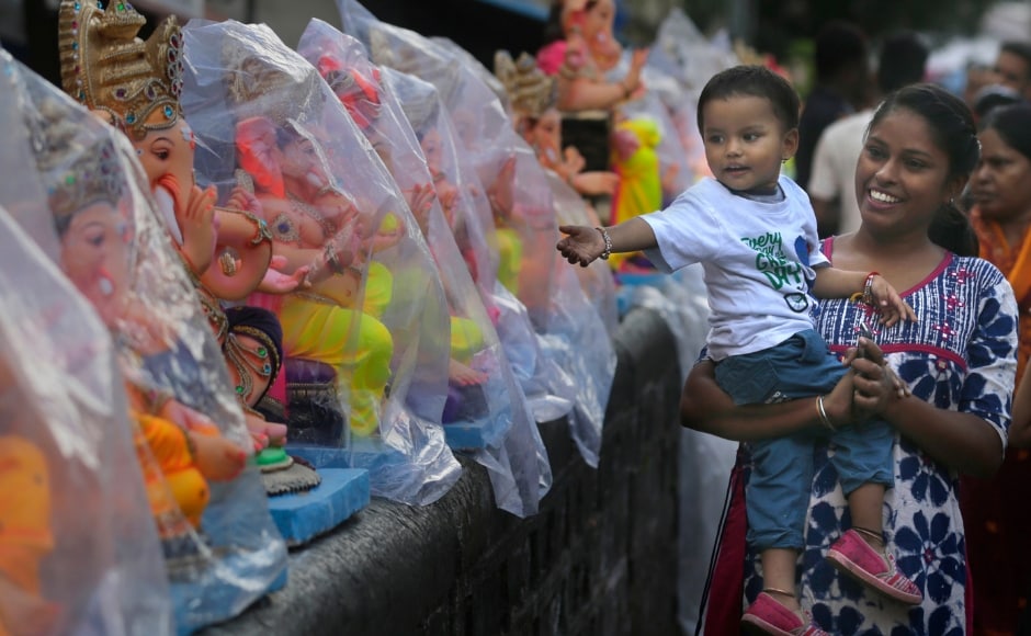 A woman walks along with her daughter passes the idols of elephant-headed Hindu god Ganesha in Mumbai on the day of Ganesh Chaturthi. Hundreds of artists work for months to create idols of the lord in several sizes which are then housed in the temples of thousands of homes during the festival. The Associated Press/ Rafiq Maqbool A woman walks along with her daughter passes the idols of elephant-headed Hindu god Ganesha in Mumbai on the day of Ganesh Chaturthi. Hundreds of artists work for months to create idols of the lord in several sizes which are then housed in the temples of thousands of homes during the festival. The Associated Press/ Rafiq Maqbool