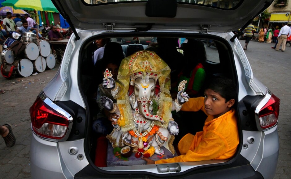 A boy sits with an idol of Ganesha in the trunk of a car on the day of Ganesh Chaturthi in Mumbai which fell on 13 September in 2018. The Associated Press/ Rafiq Maqbool A boy sits with an idol of Ganesha in the trunk of a car on the day of Ganesh Chaturthi in Mumbai which fell on 13 September in 2018. The Associated Press/ Rafiq Maqbool