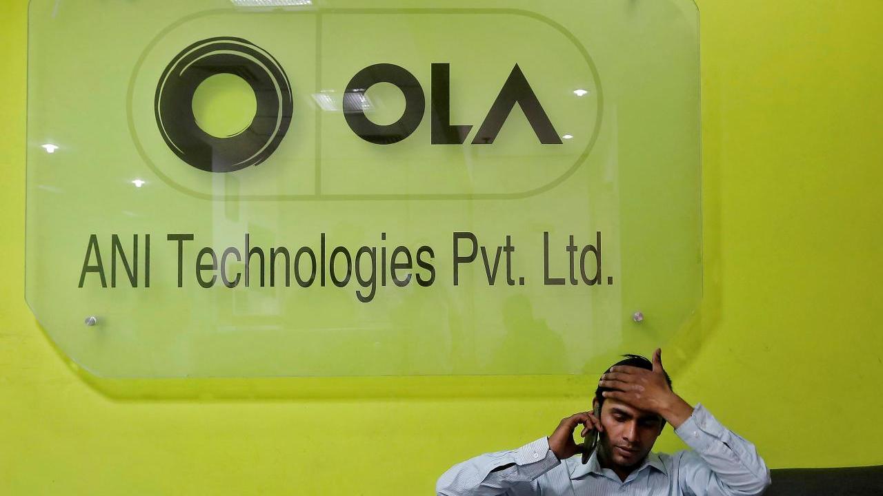FILE PHOTO: An employee speaks over his phone as he sits at the front desk inside the office of Ola cab service in Gurugram, previously known as Gurgaon, on the outskirts of New Delhi, India, April 20, 2016.  REUTERS/Anindito Mukherjee