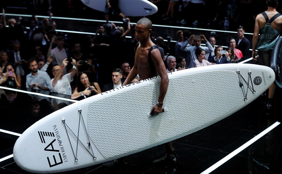 Male models, dressed like surfers and carrying their boards, opened the runway show for what was a 20-minute long spectacle of colours, fabrics, shapes and combinations for the new collection of Emporio, one of Giorgio Armani’s clothing lines. Reuters/Stefano Rellandini Male models, dressed like surfers and carrying their boards, opened the runway show for what was a 20-minute long spectacle of colours, fabrics, shapes and combinations for the new collection of Emporio, one of Giorgio Armani’s clothing lines. Reuters/Stefano Rellandini