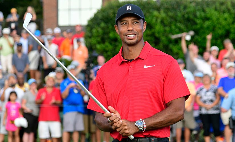 Tiger Woods holds Calamity Jane, the official trophy of the tournament, after winning the Tour Championship golf tournament Sunday, Sept. 23, 2018, in Atlanta. (AP Photo/John Amis)