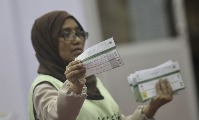 A Maldivian polling worker shows a ballot paper to monitors as she counts votes, following the end of the presidential election day in Male. AP