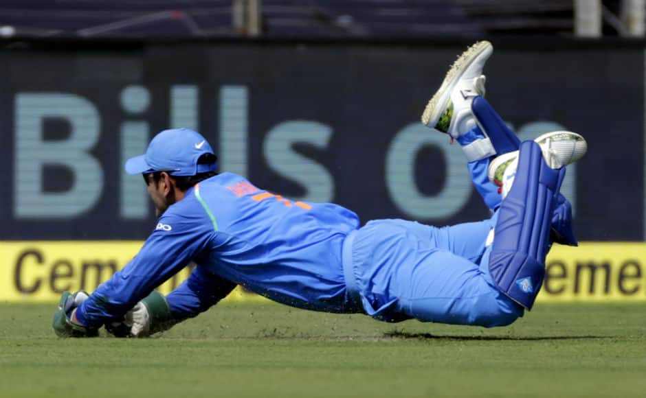 MS Dhoni takes a diving catch to result in opener Chandrapaul Hemraj's dismissal. AP