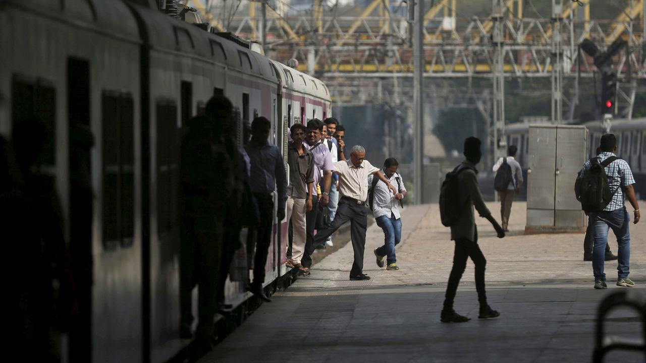 Commuters disembark from a crowded suburban train at Churchgate railway station in Mumbai, India. Image: Reuters