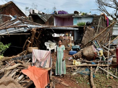 A woman stands near her damaged house hit by cyclone 'Titli', in Srikakulam. PTI
