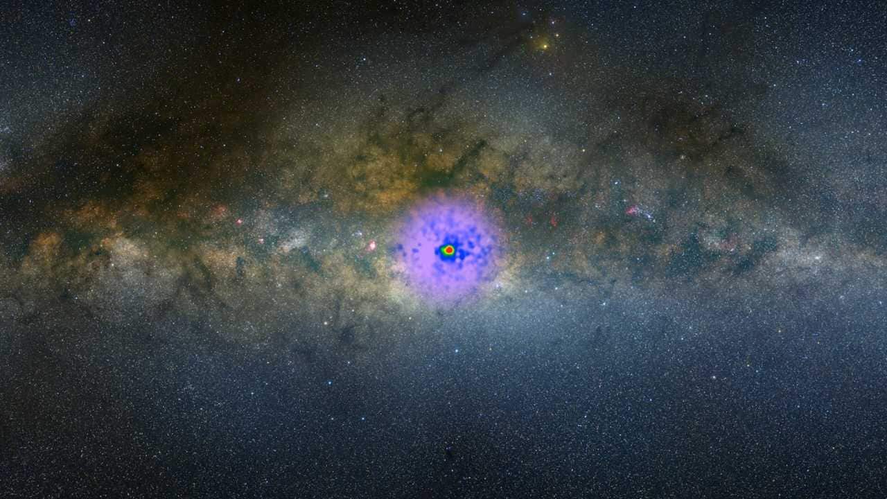 This image of the Milky Way in visible light with a superimposed gamma-ray map of the galactic center was released by NASA in Feb, 2017 from Fermi telescope data. With all known sources removed, the map shows a gamma-ray excess, hinting that it could be a cloud of dark matter. Image courtesy: NASA