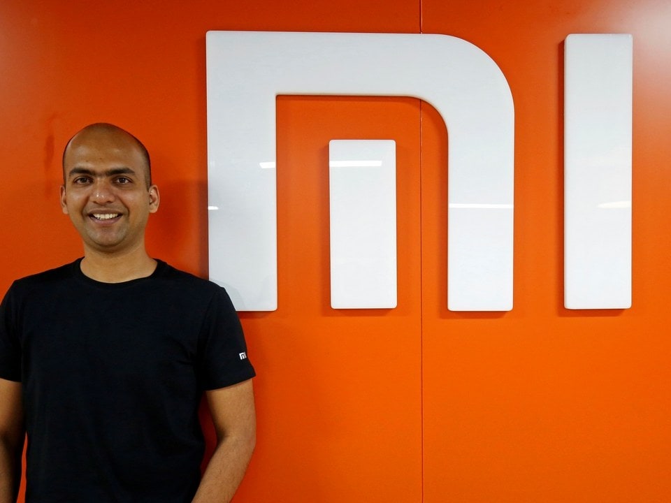 Manu Kumar Jain, Managing Director of Xiaomi India, poses next to the logo of Xiaomi in his office in Bengaluru. Image: Reuters