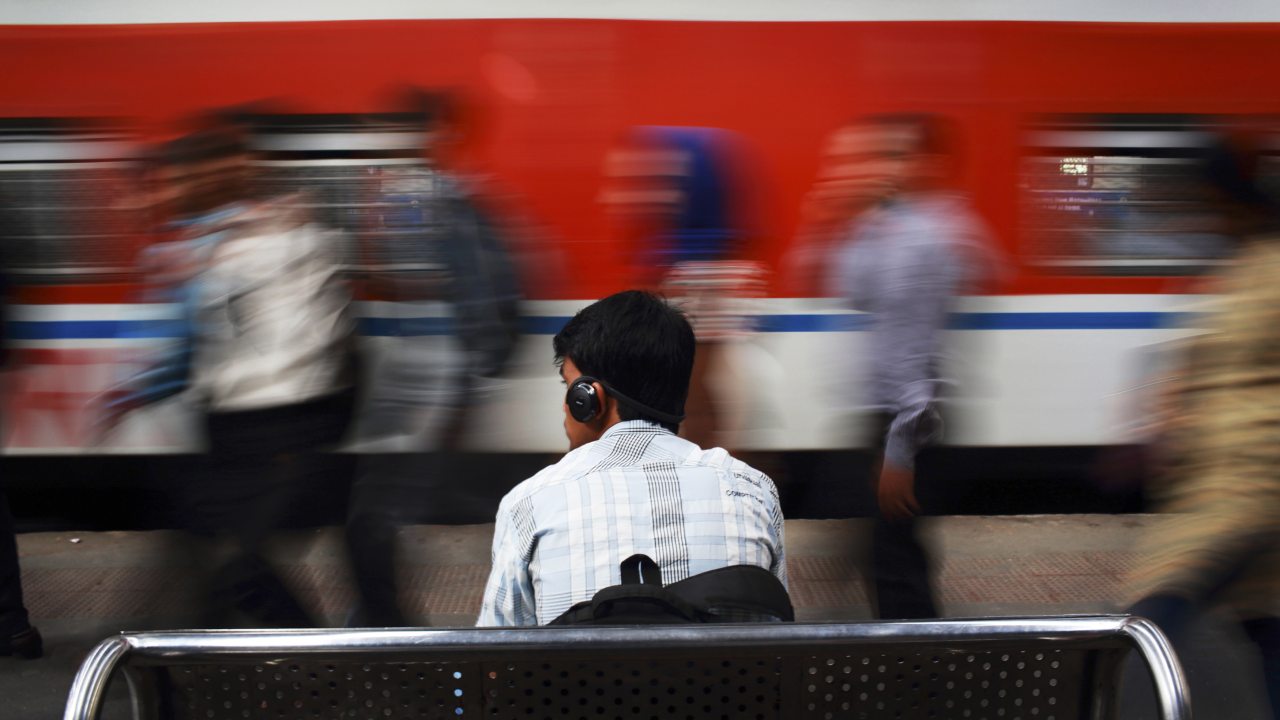 A man listens to music as he waits for his train at Churchgate railway station in Mumbai. Reuters.